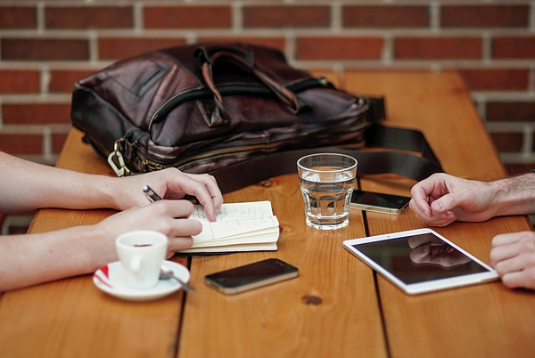 two-people-meeting-with-iphone-and-ipad-two-person-sitting-in-front-of-table-julien